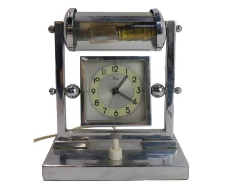 An Art Deco chromed lamp and clock, the square dial bearing Arabic numerals, on a swing frame support surmounted by a light, 
