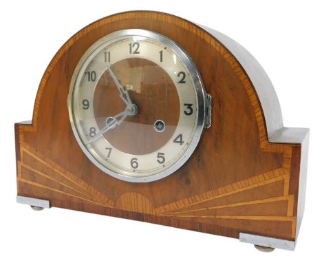 An Art Deco walnut and inlaid mantel clock, the circular dial with silvered chapter ring bearing Arabic numerals, eight day m