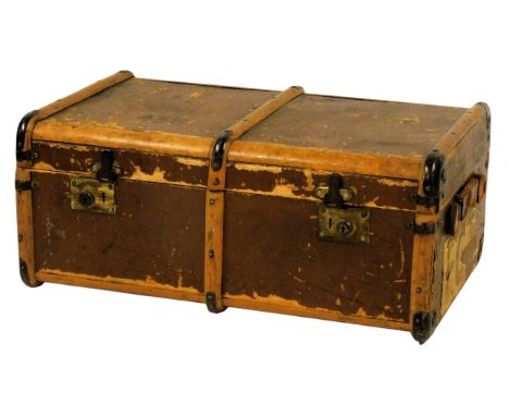 An early 20thC leather and wooden bound travelling trunk, with metal mounts, stamped for FG Tate 438, the domed lid enclosing