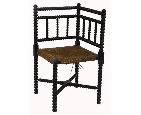 A late 19thC/early 20thC bobbin corner chair, with rush seat and X shaped stretcher, 70cm high.