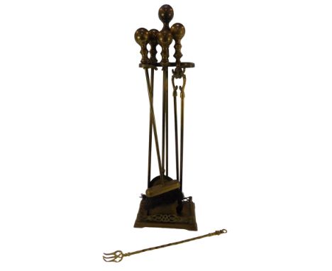 A brass fireside companion set, comprising brush, poker, tongs and shovel, with a brass stand, of pierced scroll work rectang