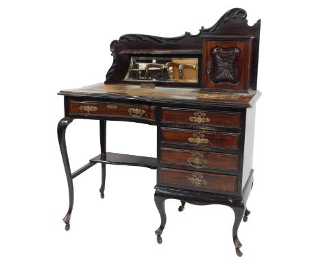An early 20thC mahogany writing desk, the scroll carved raised back with a single shelf above a bevelled mirror flanked by a 