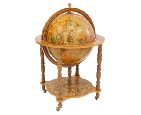 A late 20thC terrestrial globe drinks cabinet, the hinged lid enclosing four recesses for various bottles, on a gimbal stand,