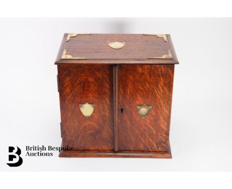An oak 20th century smokers chest, double doors open to reveal a fitted interior with pipe stand and two short and one long d