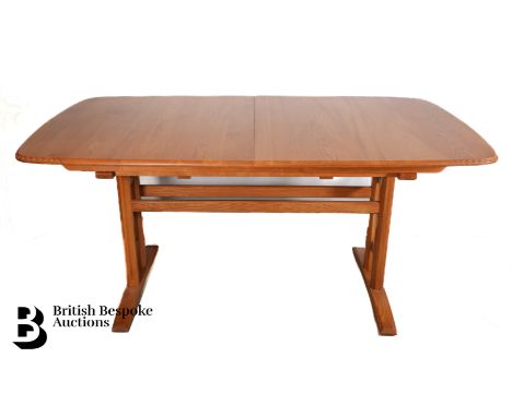 Ercol Burford 954 light elm extending dining table, having a pull-out action and three extra drop-in leaves, raised on facete