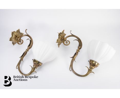 Two brass wall light fittings, in the Victorian style, with white glass shades, 40 cms in length.&nbsp;