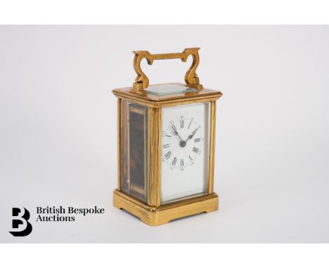 Brass 8-day carriage clock, enclosed by bevelled glass with a glass panel to allow visual access to the movement, white ename