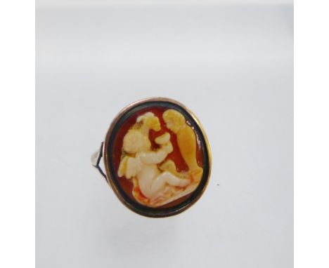 Antique cameo ring, the almost circular plaque depicting a winged cherub, set within an unmarked gold mount, likely carved sh