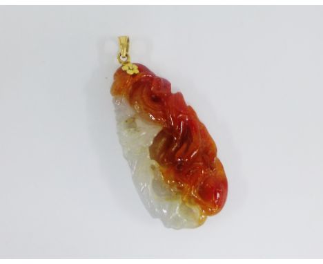 Carved jade pendant on a 14 carat gold suspension loop, 5cm long 