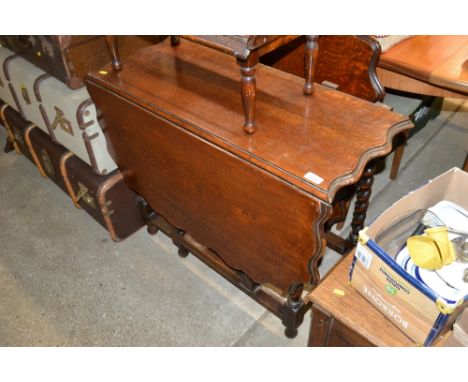 An oak gate leg table with shaped leaf, raised on barley twist supports AF