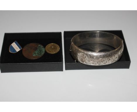 A silver snap bangle; two coins and an enamel reliant badge