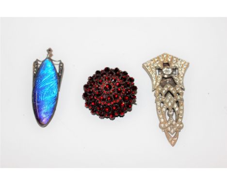 A garnet style brooch; a paste Art Deco style brooch; and an enamel and cut steel brooch