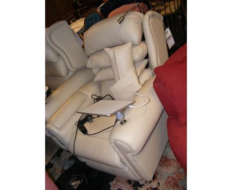 A reclining armchair upholstered in cream leather and complete with reading light and charging pad CONDITION REPORT.