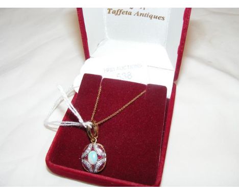An opal, ruby and diamond pendant on gold chain