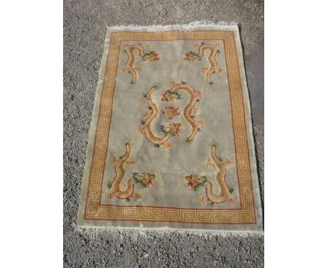 Chinese embossed washed woollen rug, green ground set with Chinese dragons chasing a flaming pearl, Greek key border (186cm x