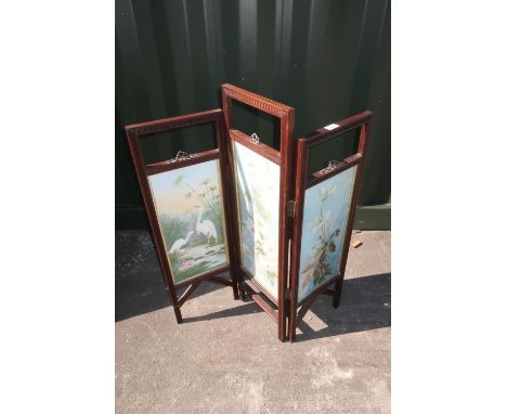 Edwardian oak framed two fold firescreen, the three rectangular panels painted with storks and flowers, with gilt metal ribbo