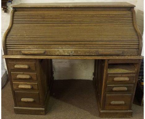 A Lebus Oak Roll Top Desk, circa 1930s, Having a tambour shutter enclosing a fitted interior, raised on two four drawer pedes