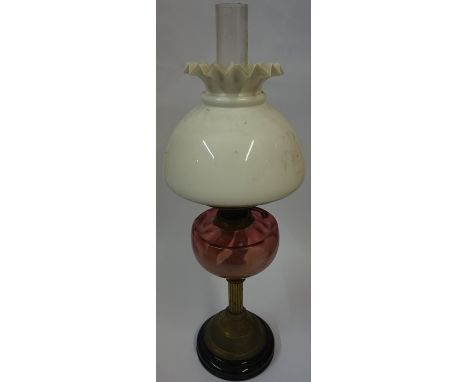 A Vintage Brass Corinthian Style Oil Lamp, Having a cranberry glass reservoir, with shade, 40cm high