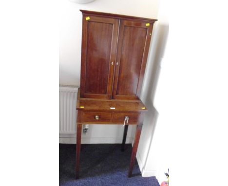 A George III mahogany cleric's cabinet, the upper section with two panel doors, and pigeon hole and drawers to the interior, 