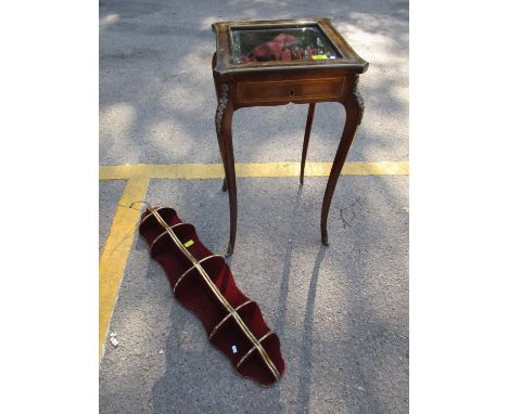 Mahogany and inlaid brass display table with glazed top, applied brass plaques to the legs, and a giltwood display wall hangi