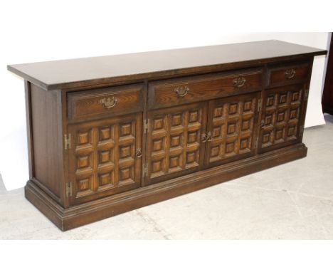 A contemporary oak Spanish-style sideboard, three frieze drawers over four panel doors to plinth base, 205 x 74cm.