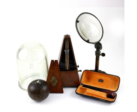 An Edwardian desk-standing magnifying glass, a bowling ball, an early 20th century glass dome, a French mahogany-cased metron