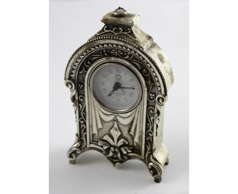 An Ottaviani white metal ornate mantel clock, the white dial set with Roman numerals and inscribed 'Ottaviani 1945', height 1