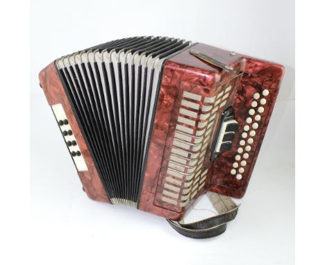 An accordion with marble-effect red body, numbered '077213'.