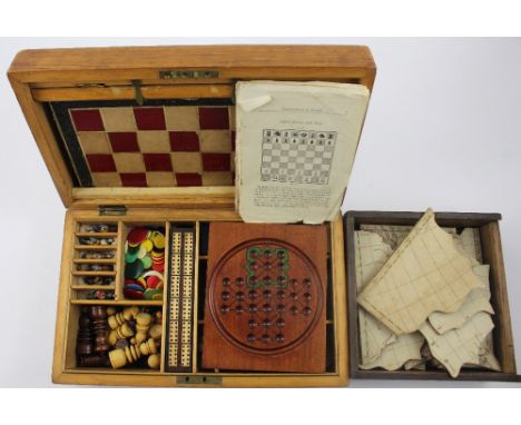 A late 19th century walnut-cased games compendium comprising chess pieces, a racing game, cribbage, draughts, dominoes, solit