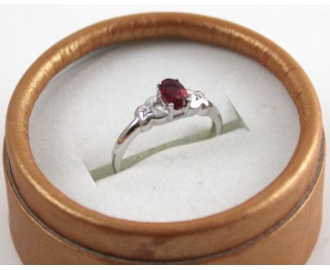 A 9ct white gold ladies' dress ring set with central spinel and chip diamond shoulder mounts, size N, approx 2g.