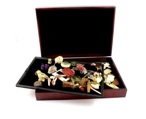 A mahogany velvet-lined case containing an exquisite collection of Victorian and Edwardian pincushions, tape measures, needle