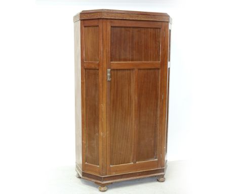 A c1930 mahogany panelled hall robe with canted corners, the single panel door surmounted by pressed wood floral frieze, heig