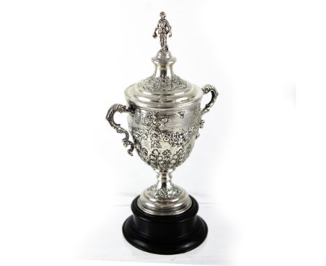 A George V hallmarked silver twin-handled golfing trophy, heavily decorated with repoussé floral decoration and figural knop,