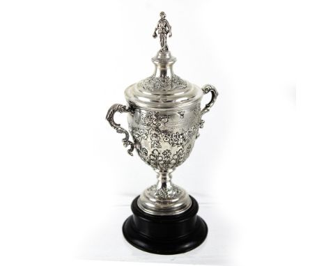 A George V hallmarked silver twin-handled golfing trophy, heavily decorated with repoussé floral decoration and figural knop,