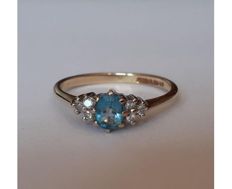 A 9ct gold and pale blue stone ring flanked by 3 diamonds to either side, total weight 1.5g, UK ring size N. Location: RING 