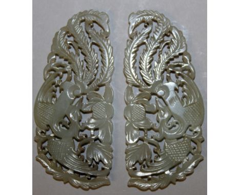 A MIRROR PAIR OF CHINESE CELADON JADE PIERCED & SHAPED PLAQUES, each decorated with a phoenix and peony, each 2.6in wide x 1.