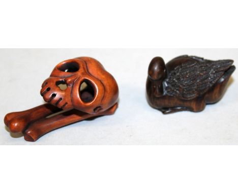 A SIGNED JAPANESE WOOD NETSUKE, in the form of a skull with bones, the reverse with an engraved signature, 2.25in high; toget