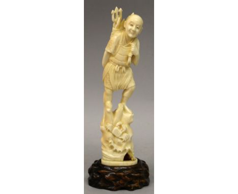 A SIGNED JAPANESE MEIJI PERIOD IVORY OKIMONO OF A FISHERMAN, together with a fitted wood stand, the man standing on a sandy m