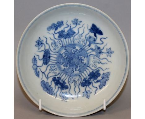 A CHINESE BLUE & WHITE PORCELAIN SAUCER DISH, the interior decorated with lotus encircling a central panel of stylised waves,