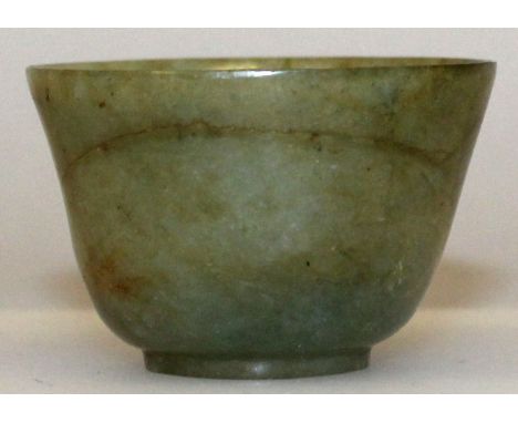 A SMALL GOOD QUALITY CHINESE JADE BOWL, the predominantly green stone with numerous russet inclusions, the base carved with a