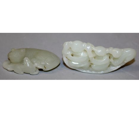 A CHINESE CELADON JADE MODEL OF THREE BOYS, on a narrow leaf, 3.25in long; and a celadon jade-like model of a buddhistic lion