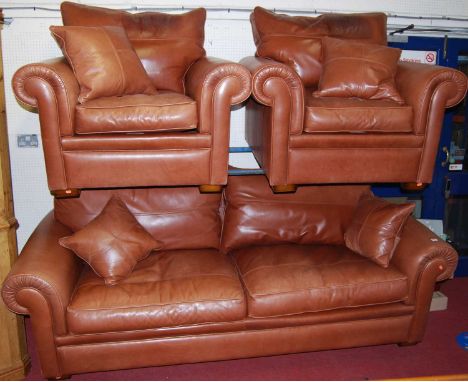 A contemporary Duresta tan leather three piece suite, comprising; three seater sofa and pair of armchairs, each raised on squ