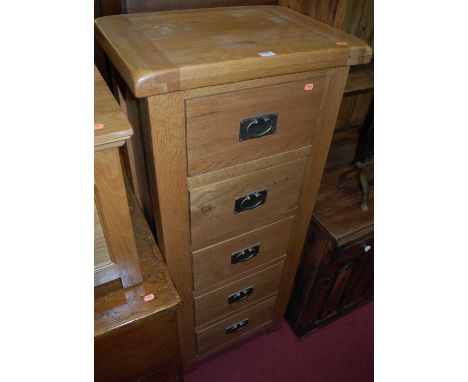 A contemporary joined light oak narrow chest of five drawers, w.55cm