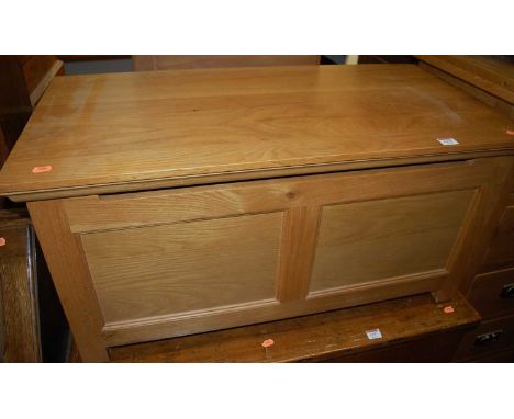 A contemporary light oak twin panelled hinge topped blanket box, w.90cm