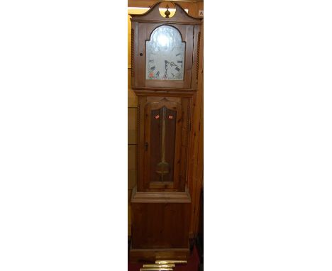 A contemporary pine long case clock, the arched dial signed Ely, with glazed trunk door and three train weight driven movemen