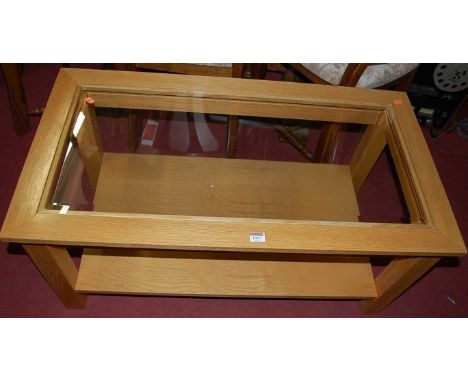 A contemporary light oak and clear glass inset  two-tier coffee table, length 99cm