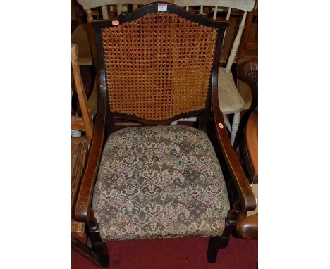 An early 20th century oak cane back and floral tapestry seat open armchair, w.56cm 