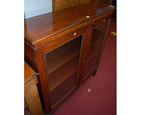 A circa 1900 mahogany double door glazed bookcase, raised on square supports, width 110.5cm