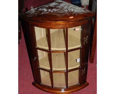 A contemporary mahogany bow front hanging single door glazed corner cupboard