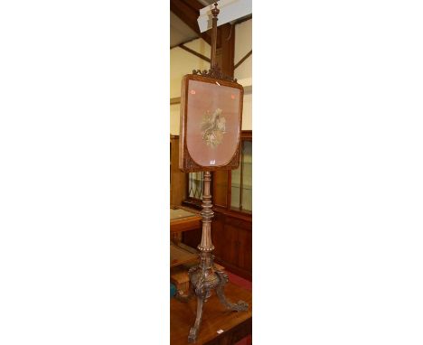 A mid-Victorian figured walnut needlework tapestry inset pole screen, raised on acanthus leaf carved supports 
